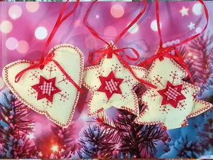 Detailed shot of handmade felt Christmas tree ornaments in heart, star, and tree shapes