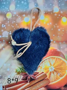 Detalle del adorno de corazón de felpa azul oscuro sobre un fondo festivo cálido