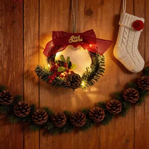 Lit Christmas wreath detail with red bow, pinecones, and Merry Christmas sign