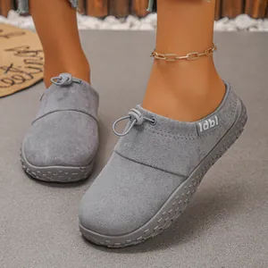 Close-up detail of grey suede slip-on shoes featuring a toggle drawstring closure