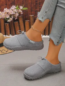 Close-up of comfortable grey suede slip-on loafers for women with stylish lace detail.