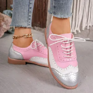 Primer plano detallado de zapatos brogue rosas y plateados para mujer con cordones