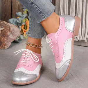 Primer plano de zapatos Brogue tricolores para mujer con perforaciones y diseño de cordones