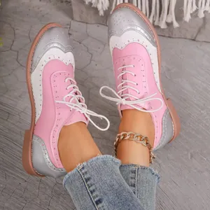Primer plano de zapatos Oxford brogue de patchwork rosa y plata con cordones de moda