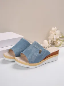 Gros plan de mules à talons compensés en denim pour femmes avec détails usés