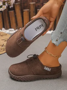 Macro detail showing the texture of brown suede wedge clogs with adjustable drawstring.
