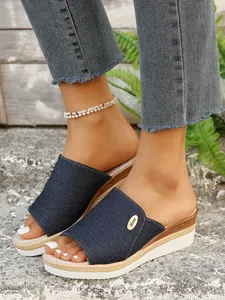 Gros plan de mules à talons compensés en denim pour femmes avec semelles plateformes.