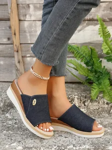 Vue macro montrant la texture de la tige en denim bleu et du talon compensé tressé