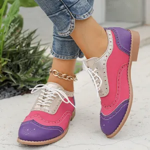 Primer plano de zapatos Brogue coloridos para mujer con parches rosas y púrpuras.