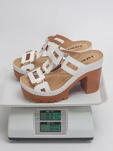 Mesure du poids d'une sandale compensée blanche sur balance affichant 0,31 kg légère