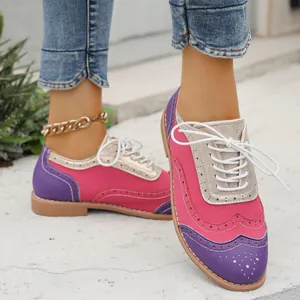 Primer plano de zapatos brogue de colores para mujer en ante rosa y violeta con oro.