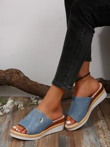 Détail rapproché des mules compensées en denim pour femmes avec bordure espadrille.