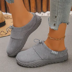 Close-up of grey suede slip-on shoes with drawstring and textured rubber sole.
