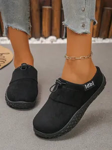 Macro detail of comfortable black suede slip-on shoes featuring a bungee lace design