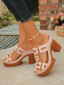 Gros plan sur des mules roses à plateforme et talons épais avec boucles métalliques