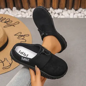 Close-up of black suede loafers with adjustable drawstring laces and brand logo.