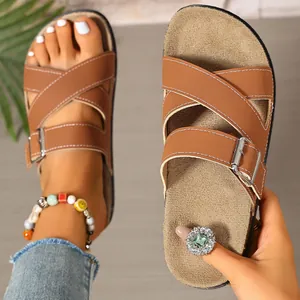 Detailed view of stylish brown cross-strap cork sandals featuring adjustable silver buckles