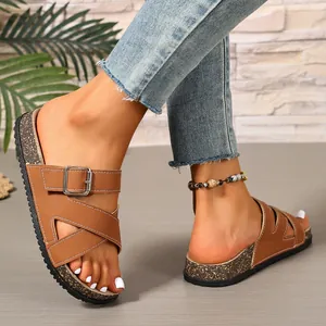 Close-up of brown cross-strap cork sandals with adjustable buckle for casual beach wear