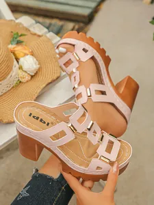 Détail de sandales à plateforme roses avec boucles métalliques et talons hauts marrons