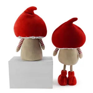 Dettaglio di due gnomi natalizi in peluche con cappucci a fungo rossi e braccia a righe