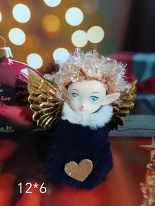 Close-up of a plush Christmas angel girl ornament with golden wings and a heart detail.