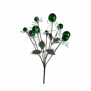 Close-up detail of a festive Christmas pick featuring glossy green balls and white ribbon bows
