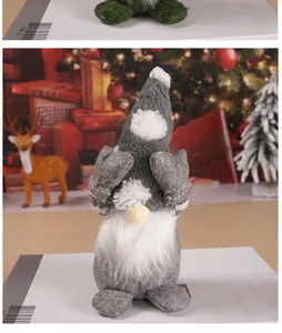 Detalle de un gnomo de Navidad de pelpa cubriéndose los ojos con unos guantes grises