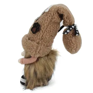 Dettaglio vista laterale di uno gnomo di peluche a tema cane con cappello sherpa marrone.