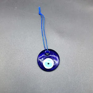 Detailed shot of a blue glass Evil Eye pendant charm with a vibrant Nazar motif and blue cord