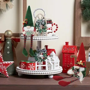 Detailed view of two Christmas gnomes on a white decorative tray with holiday props