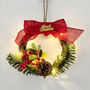 Detailed view of Christmas wreath featuring red burlap bow, warm LED lights, pine cone and berries