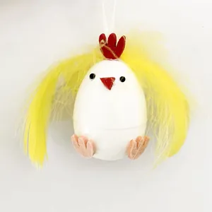 Detalle de un lindo pollito de Pascua hecho de un huevo de plástico y plumas