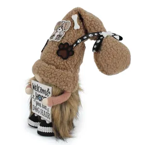 Dettaglio di uno gnomo di peluche marrone con cartello Welcome Hope you like dog hair