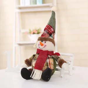 Detailed view of a plush Christmas snowman doll with plaid hat and red scarf on a mini bench