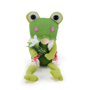 Detailed view of a green frog gnome plush holding white flowers for home decor