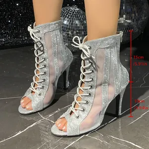Primer plano de botas de aguja con purpurina plateada, tacón de 10 cm y paneles de malla