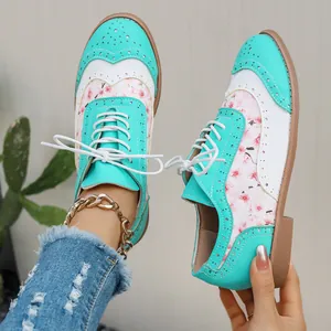 Detalle de zapatos Brogue de mujer con estampado floral verde azulado y cordones blancos.