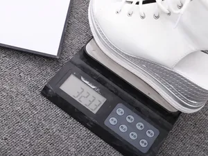 Detailed view of a white platform wedge sandal being weighed on a digital scale for accuracy