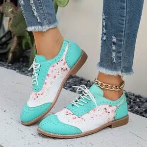 Vista detallada de los zapatos Brogue florales verde menta para mujer con cordones blancos.
