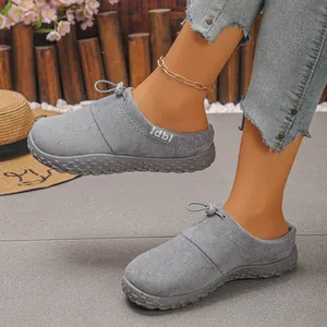 Detailed view of grey suede clogs featuring a toggle lace and textured sole.