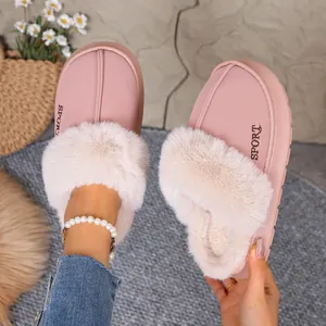 Close-up view of pink winter slippers featuring plush faux fur trim and sport branding.