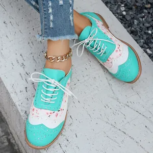 Detalle de zapatos brogue para mujer en azul y blanco con estampado floral y cordones blancos.