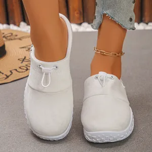 Close-up front view of white suede slip-on shoes with bungee drawstring closure