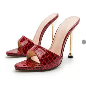 Detailed view of wine red croc-embossed pointed toe mules with gold stiletto heels