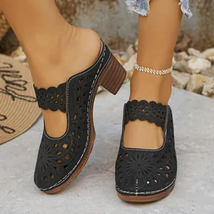 Stylish black laser-cut chunky heel mules for women in a rustic outdoor setting