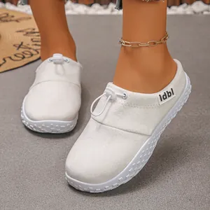 Close-up of off-white slip-on mules with drawstring toggle and side label detail