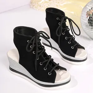 Detailed view of black lace-up peep-toe wedge sandals with silver shimmer platform heels
