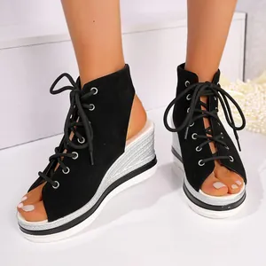 Detailed view of women's black suede lace-up wedge sandals with silver platform heel