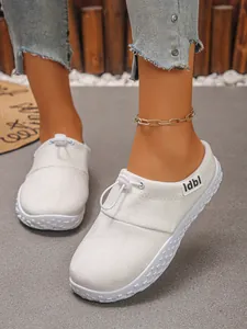 Close-up detail of white vintage lace-up women's slip-on shoes with soft matte finish