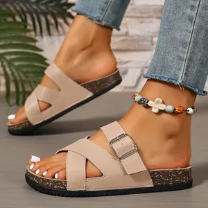 Close-up of stylish beige cork slide sandals with adjustable buckle and cross strap